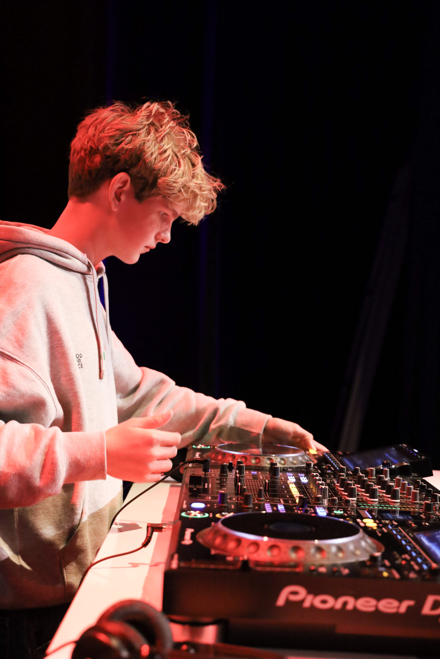 Leerling achter de DJ-set op het podium